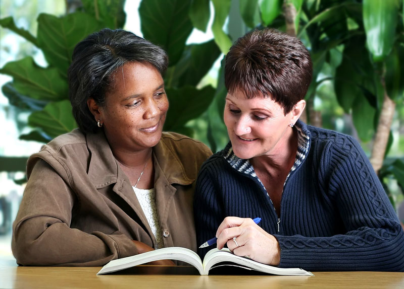 A literacy tutor assists an adult learner