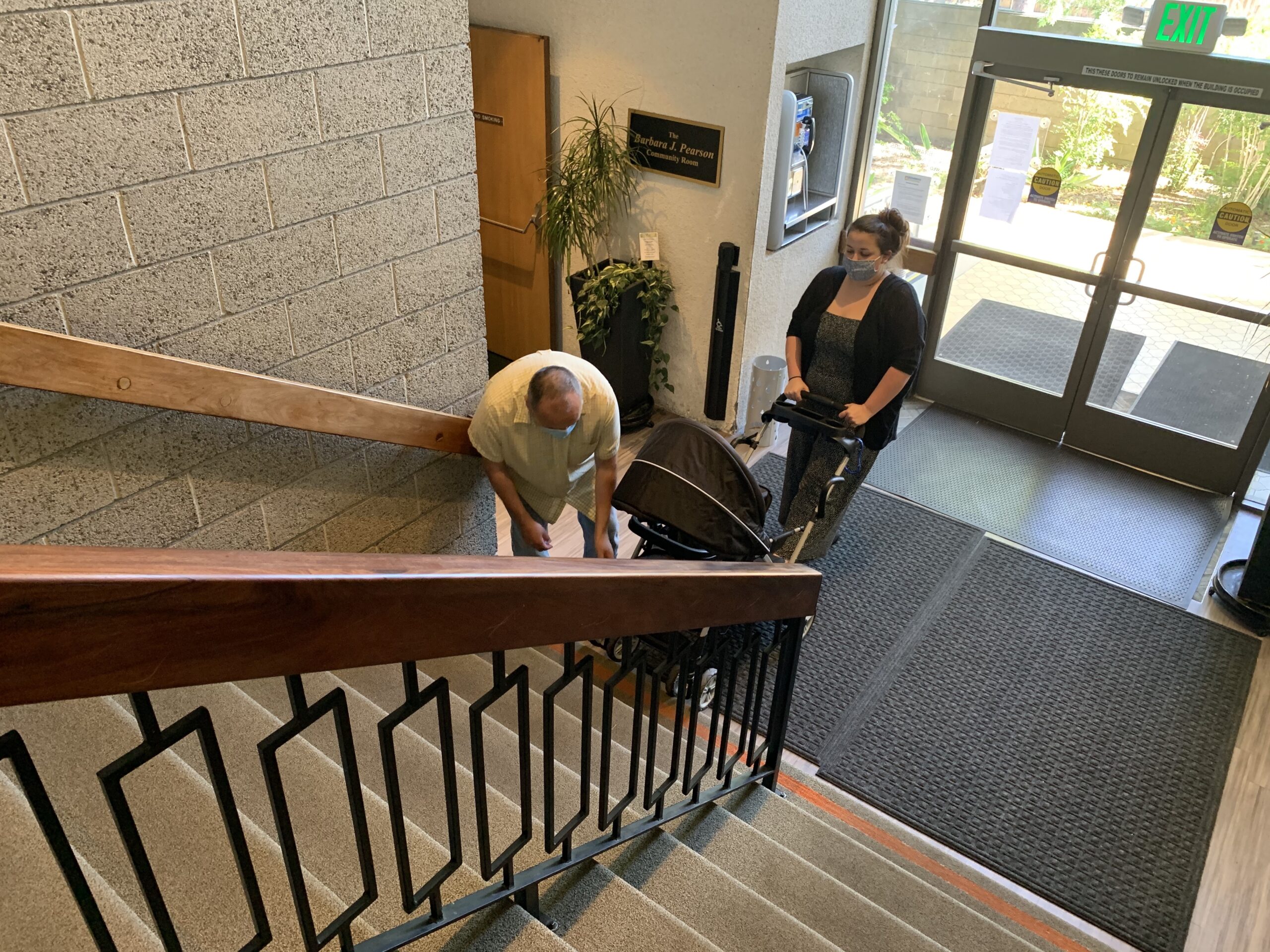 Woman needs assistance to carry stroller upstairs to get into library